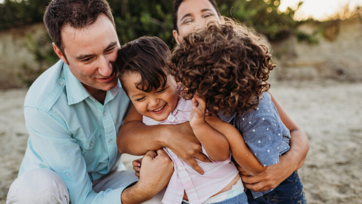A family with their two children hugging.