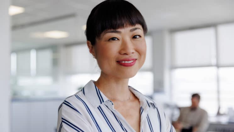 Portrait of smiling asian businesswoman at workplace