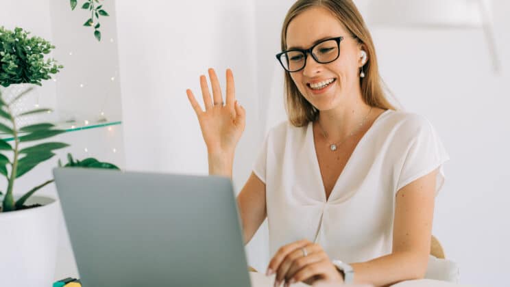 Young woman on teleconference, using laptop